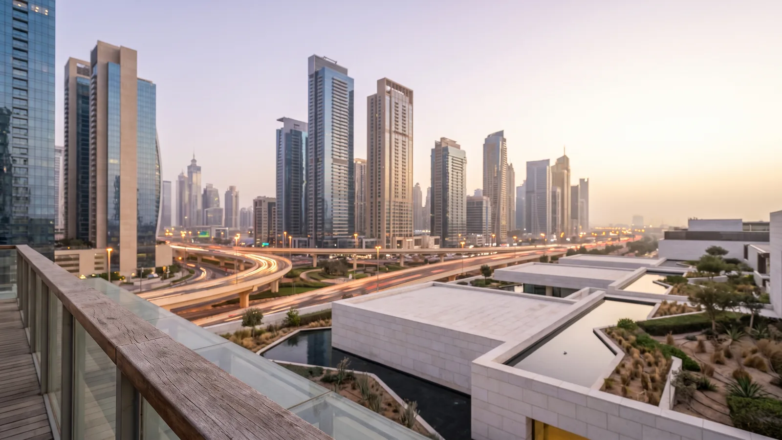 Moderne Wolkenkratzer und geschwungene Autobahnen in Dubai im weichen Licht eines sommerlichen Sonnenuntergangs.