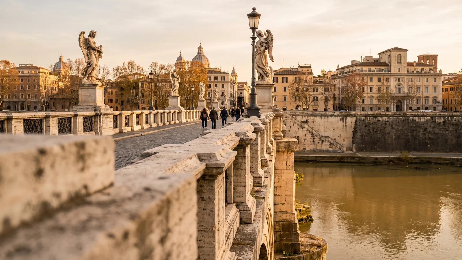 Blick über die historische Engelsbrücke mit barocken Marmorstatuen über dem Tiber im warmen Abendlicht in Rom.