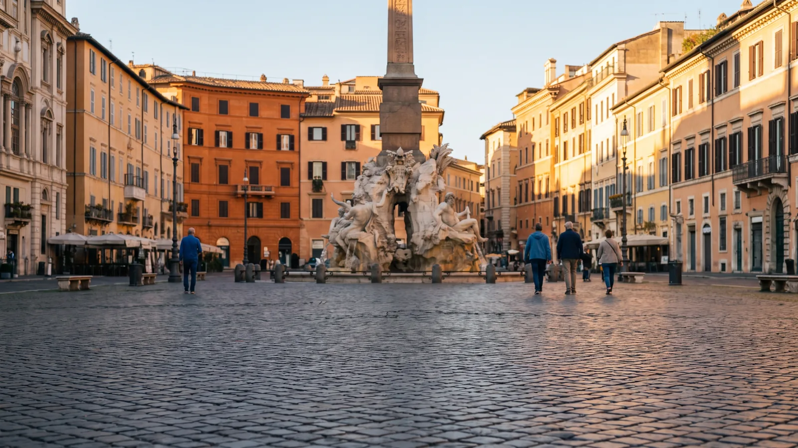 Blick über das Pflaster der Piazza Navona mit Brunnen und barocken Stadthäusern im warmen Herbstlicht Roms.