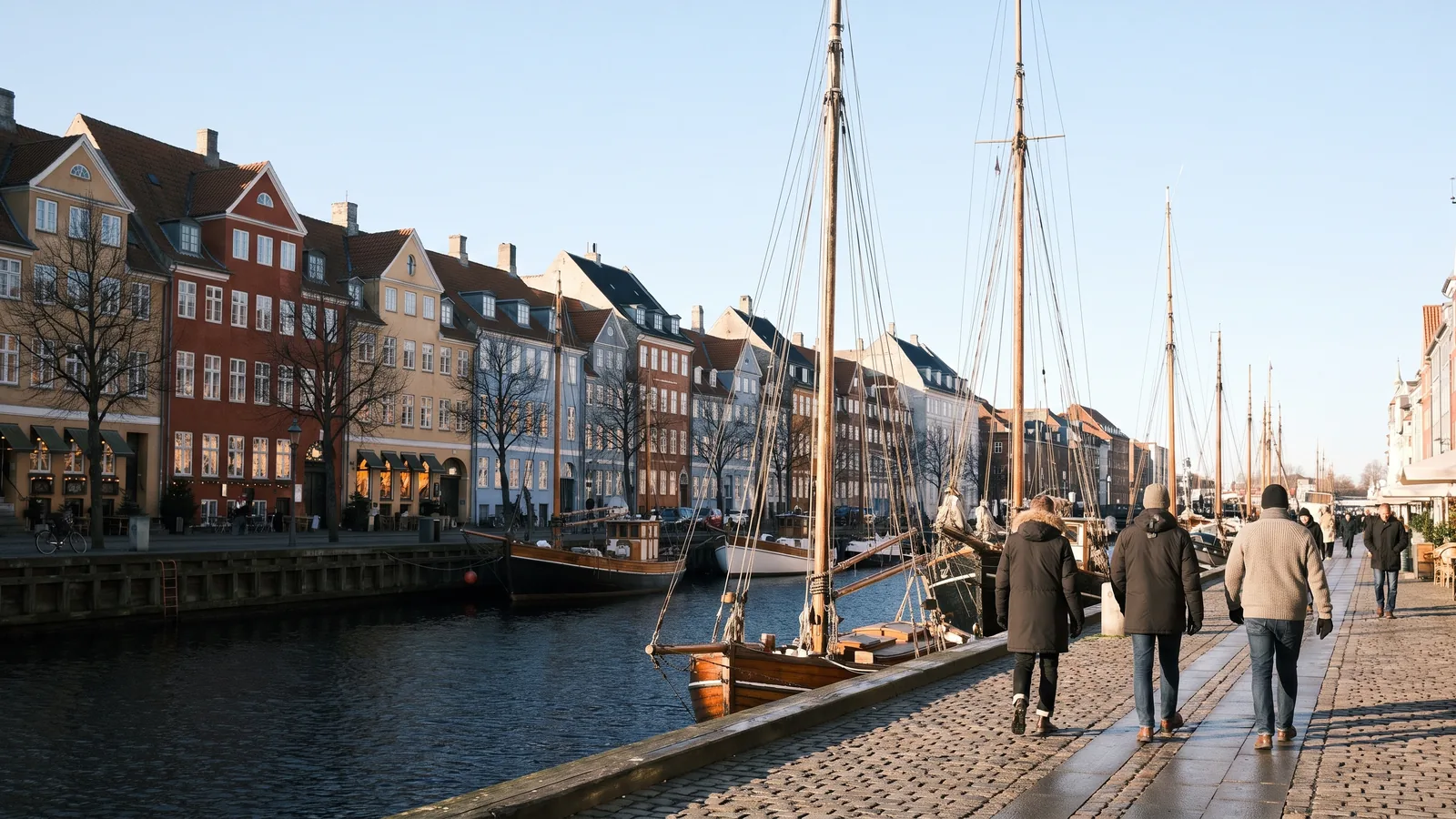Historischer Nyhavn Kanal in Kopenhagen mit bunten Stadthäusern und Holzbooten im kühlen Winterlicht eines Februarnachmittags.