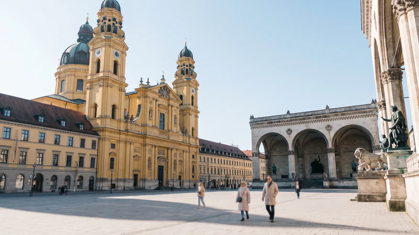 Der weite Odeonsplatz mit der markanten gelben Theatinerkirche und der Feldherrnhalle im klaren Vorfrühlingslicht Münchens.