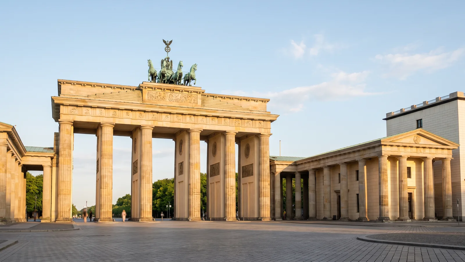 Das Brandenburger Tor in Berlin mit Sandsteinsäulen und Quadriga im warmen Sonnenlicht eines Junitages.